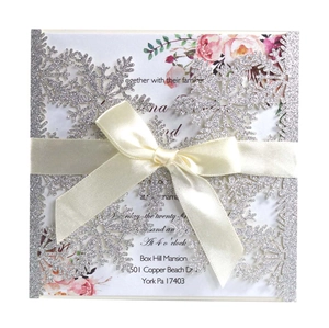 Silver laser cut snowflake wedding invitation with glitter finish and satin ribbon bow
