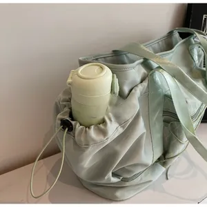 Detail view of water bottle side pocket on mint green waterproof fitness bag