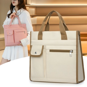 Detail of multi-pocket canvas tote bag showing reinforced handles and storage sections