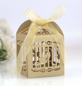 Detail of laser-cut bird and flower patterns on a kraft paper wedding favor box