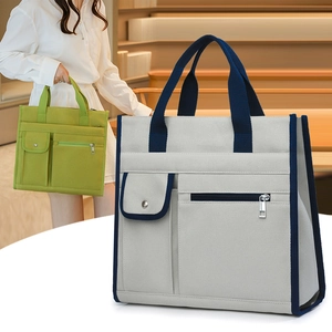Detail of canvas tote bag showing multiple pockets, durable handles and stylish grey color
