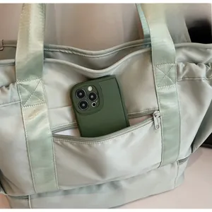 Close-up of mint green travel bag front pocket showing phone storage capacity