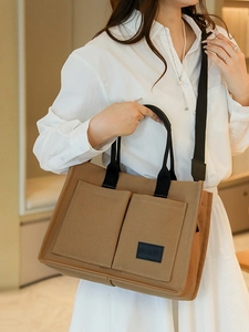 Grand sac cabas en toile marron avec multi-poches et large bandoulière porté par mannequin