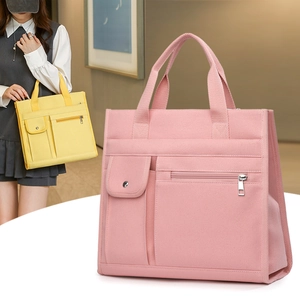 Detailed close-up of pink canvas tote showing front snap pocket and zipper pocket design