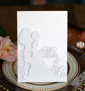 Détail d'invitation de mariage découpée au laser avec silhouettes Mr & Mrs sur papier perlé