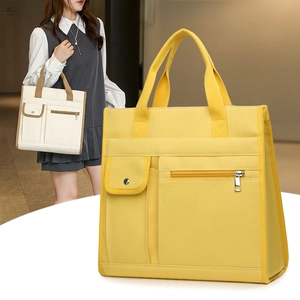 Close-up of a large capacity yellow canvas tote bag with front snap pocket and dual handles