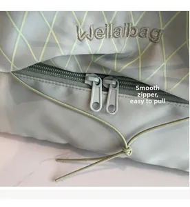 Detail of grey travel bag with smooth double zipper and Wellalbag brand embroidery