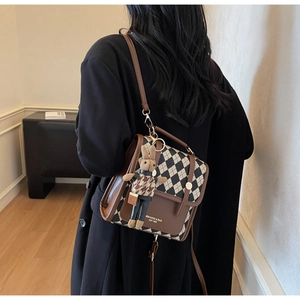Retro plaid shoulder bag featuring brown leather trim and cute rabbit doll keychain charm