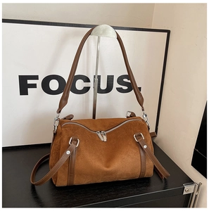 Detail of a brown suede Boston bag featuring double zipper top and silver hardware accents