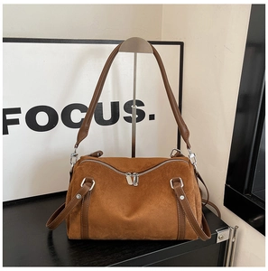 Detail of vintage brown suede pillow bag featuring silver hardware and a side shoulder strap