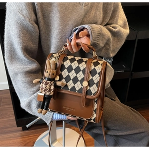 Detail of checkered crossbody bag with leather trim and cute bunny plush pendant