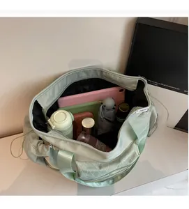 Interior view of mint green travel bag filled with tablet, umbrella and cosmetics