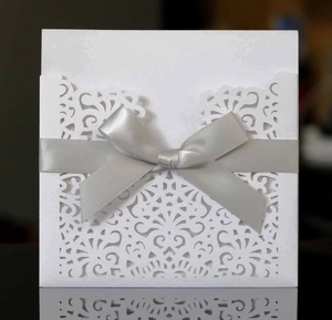 Détail du faire-part découpé au laser avec motif géométrique et ruban en soie argent