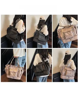Detail view of large capacity nylon travel bags in black and khaki shown by a model