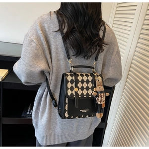 Close-up of vintage argyle pattern mini backpack with plush bunny and golden buckle