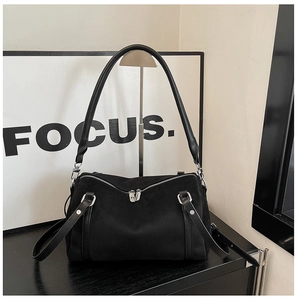 Close-up of black suede Boston bag featuring dual silver zippers and sturdy carry handles