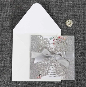 Détail de l'invitation de mariage découpée au laser avec paillettes argent et ruban gris