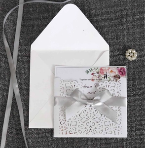 Détail de l'invitation de mariage découpée au laser avec dentelle blanche et ruban gris