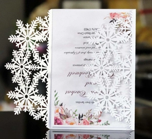 Détail macro de motifs de flocons de neige découpés au laser sur une carte d'invitation