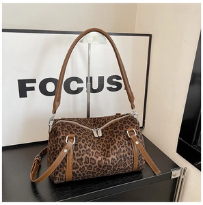 Detail of leopard print boston bag with brown leather handles and silver hardware