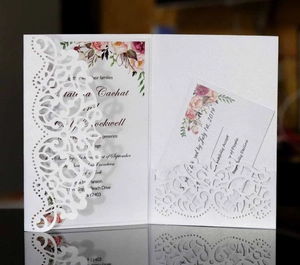 Detailed laser-cut lace floral pattern on white pearlescent wedding invitation card set