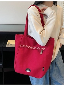 Minimalist red canvas tote bag with embroidered dog and white zigzag pattern