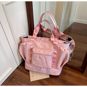 Detailed macro view of pink waterproof travel bag showing diamond pattern and shoe compartment