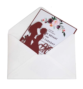 Silhouette découpée au laser d'un couple sur une carte d'invitation bordeaux à paillettes