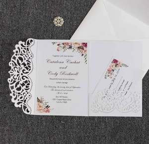 Detail of laser-cut floral wedding invitation set with pearl buckle and flower cards