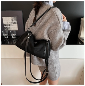 Detail of black nylon Boston bag with silver hardware and leather straps on a model