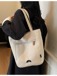 Minimalist off-white canvas tote bag with blue stitching and cute puppy embroidery