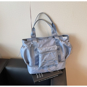 Detail of grey-blue large capacity travel bag with multiple pockets and sturdy handles