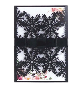 Carte flocon découpée au laser avec ruban satiné noir et détail de page florale