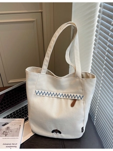 Minimalist beige canvas tote bag with puppy embroidery and wide shoulder strap