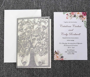 Detail of silver glitter laser-cut tree invitation with floral insert and white envelope
