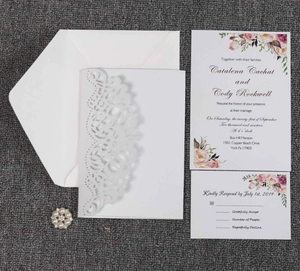 Detailed laser cut floral wedding invitation set with white envelopes and elegant cards