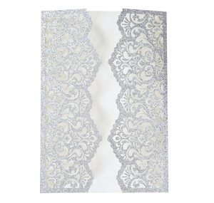 Close-up of laser-cut silver glitter wedding invitation with intricate lace vine patterns