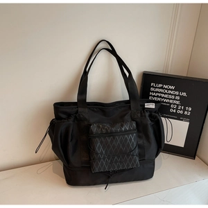 Detail view of large nylon travel bag with quilted front pocket and separate shoe compartment