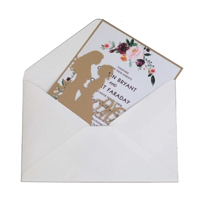 Détail de l'invitation de mariage découpée au laser avec silhouette dorée et fleurie