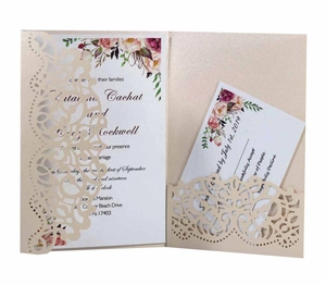 Macro view of laser-cut floral lace wedding invitation with champagne gold finish