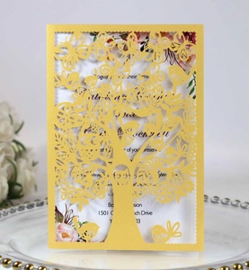 Detailed laser cut life tree and birds on a yellow paper invitation card with floral insert