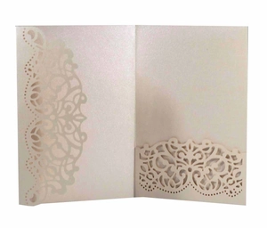 Macro view of laser-cut lace pattern on pearlescent champagne paper wedding invitation
