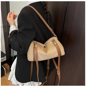 Detail of khaki suede shoulder bag with brown leather trim and silver metal buckle strap