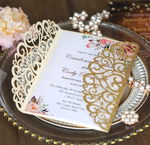 Detail of laser cut gold glitter belly band on a luxury floral wedding invitation set