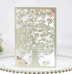Detail of laser-cut glitter tree and bird invitation card with floral insert