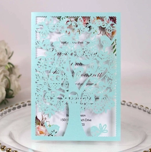 Detailed laser-cut tree design on a light blue invitation card set in an elegant scene