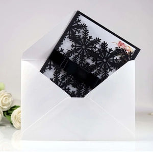 Vue détaillée de l'invitation flocon découpée au laser avec nœud en satin noir et enveloppe