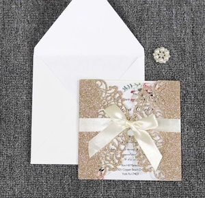 Détail de l'invitation de mariage dorée découpée au laser avec ruban et épingle perle