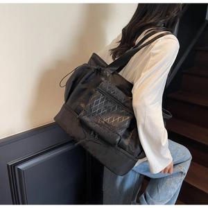 Detail of waterproof nylon travel bag with geometric patterns and spacious front pocket