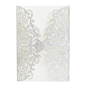 Macro detail of silver glitter laser-cut invitation with intricate floral lace texture